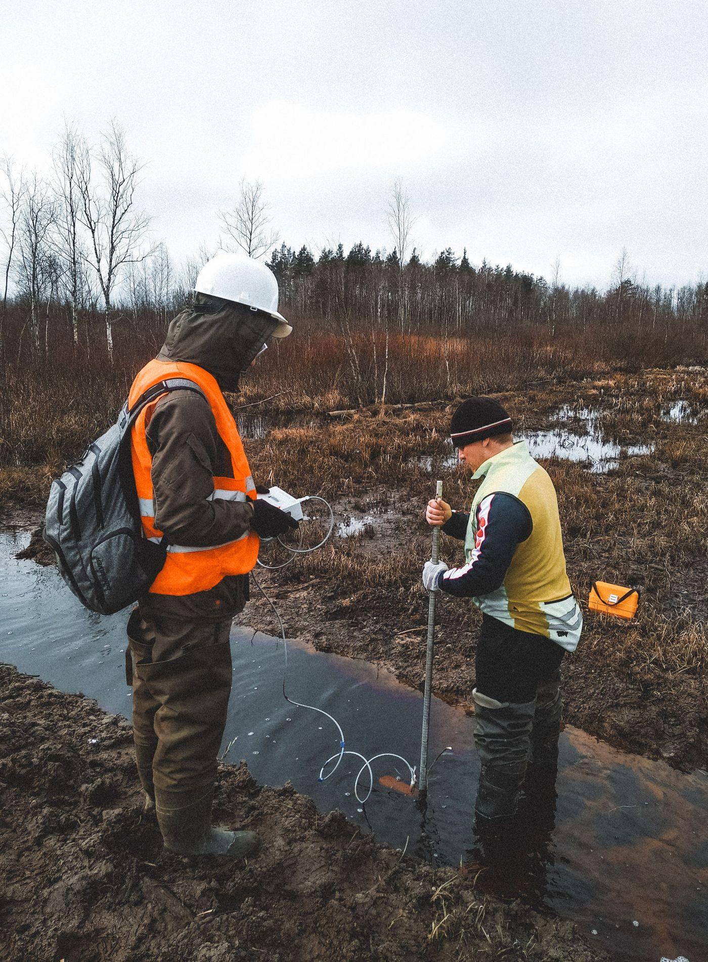 Researchers wading through shallow water carrying out on-site quality testing